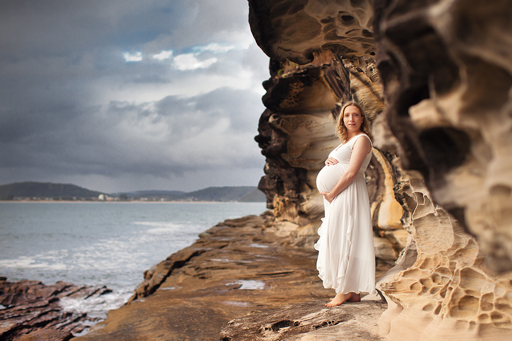 pregnant mum in white dress on pearl beach rocks